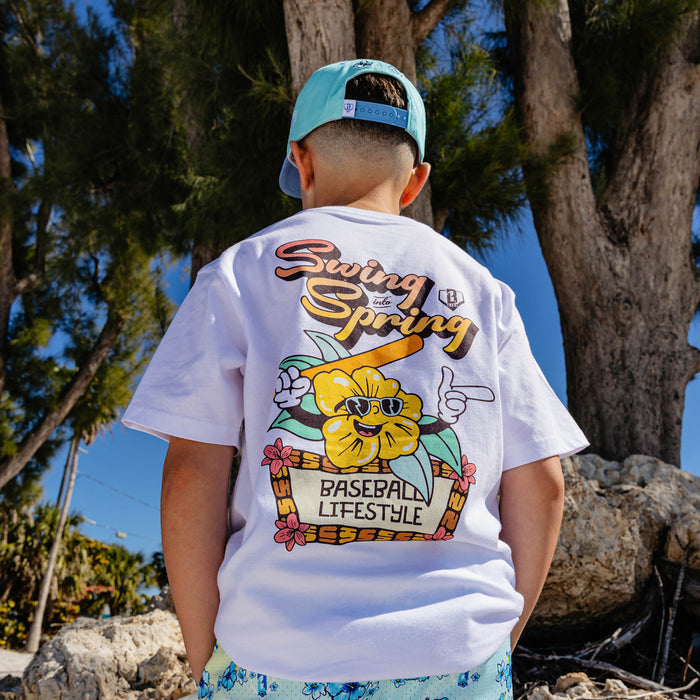 Person wearing a 'Swing into Spring' t-shirt with a flower holding a baseball bat graphic