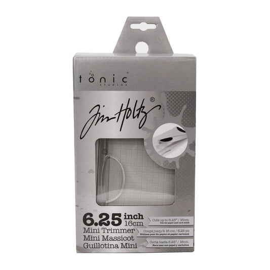 Tim Holtz - Guillotine Mini Trimmer 6.25". The Tim Holtz 6.25 inch / 16cm Mini Trimmer has many features not found in similar products. This product is portable and lightweight. It is perfect for trimming photographs and creating card fronts. Available at Embellish Away located in Bowmanville Ontario Canada.