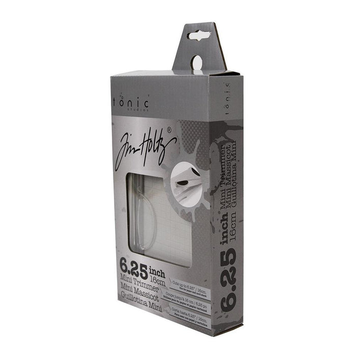 Tim Holtz - Guillotine Mini Trimmer 6.25". The Tim Holtz 6.25 inch / 16cm Mini Trimmer has many features not found in similar products. This product is portable and lightweight. It is perfect for trimming photographs and creating card fronts. Available at Embellish Away located in Bowmanville Ontario Canada.
