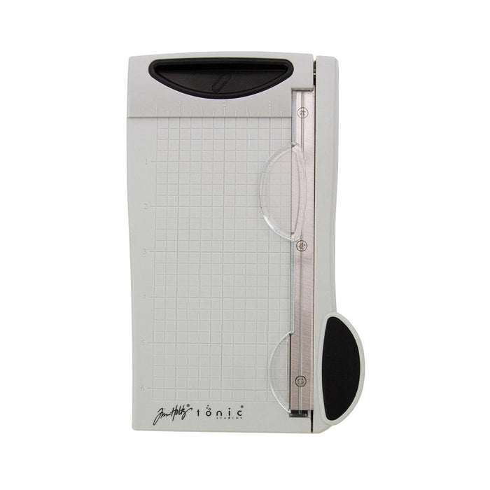 Tim Holtz - Guillotine Mini Trimmer 6.25". The Tim Holtz 6.25 inch / 16cm Mini Trimmer has many features not found in similar products. This product is portable and lightweight. It is perfect for trimming photographs and creating card fronts. Available at Embellish Away located in Bowmanville Ontario Canada.