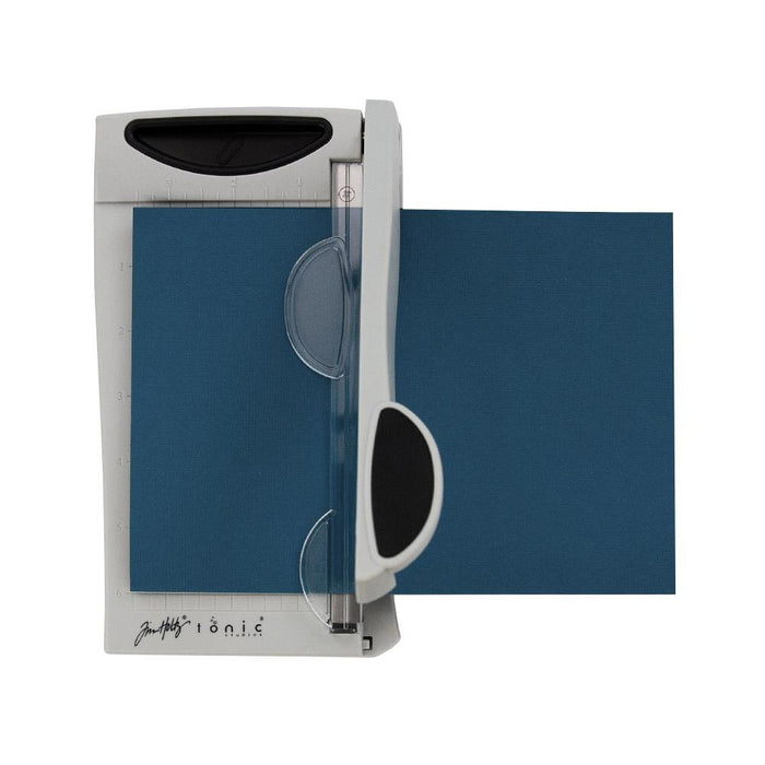 Tim Holtz - Guillotine Mini Trimmer 6.25". The Tim Holtz 6.25 inch / 16cm Mini Trimmer has many features not found in similar products. This product is portable and lightweight. It is perfect for trimming photographs and creating card fronts. Available at Embellish Away located in Bowmanville Ontario Canada.