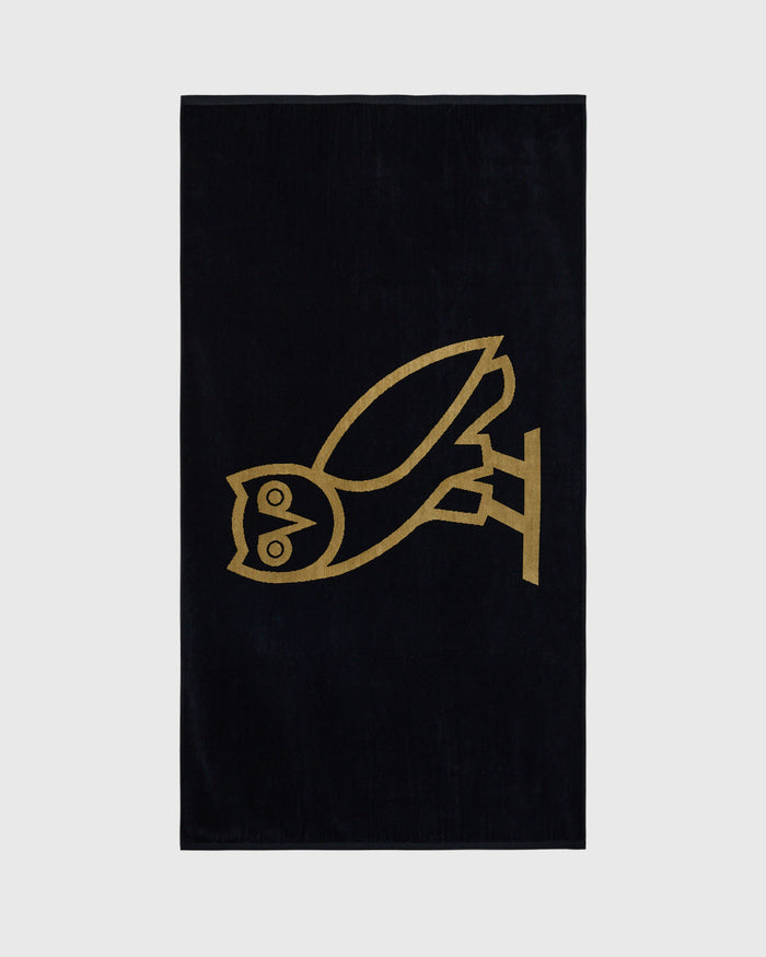 Black towel with gold line-drawn bird design in center.