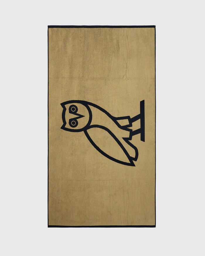 Tan towel with black border and black owl line drawing design.
