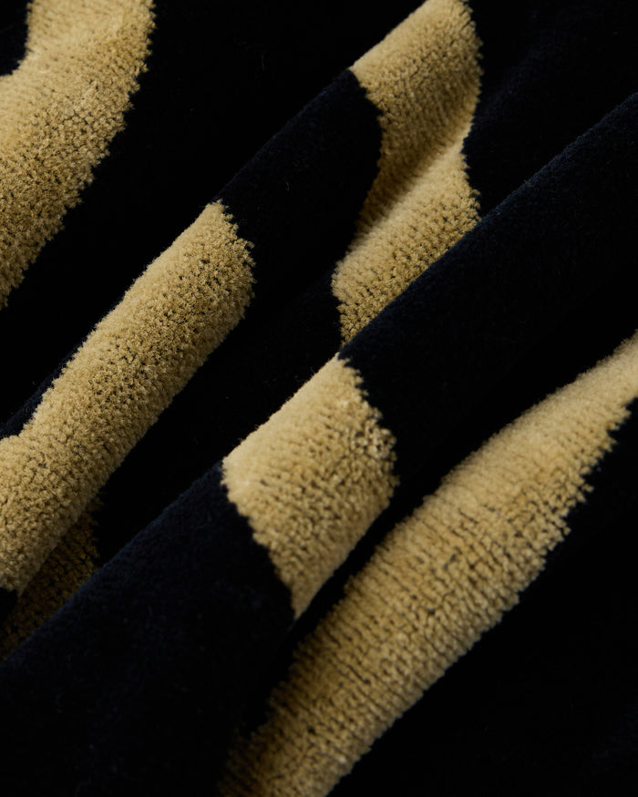 Black and tan striped towel with textured terry cloth surface.