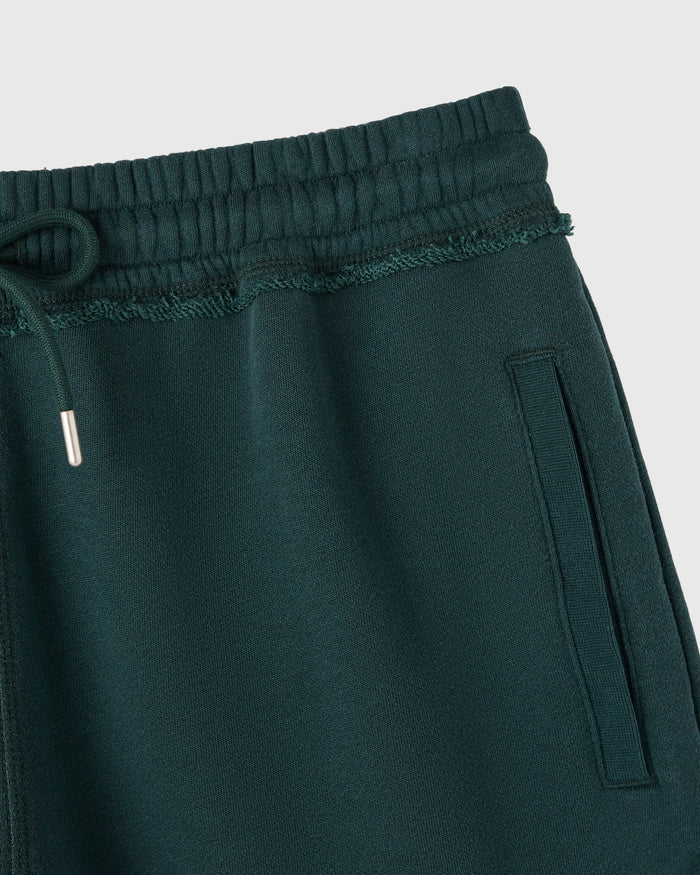 Midnight green training sweatshort with elastic waistband, drawstring, and side pocket detail.
