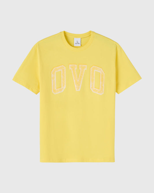 Yellow short-sleeve t-shirt with cream-colored arch graphic spelling "OVO" on chest.