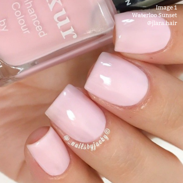 Close-up of a hand with short, square-shaped nails painted a light rose petal pink. A bottle of LONDONTOWN's vegan nail polish labeled "Waterloo Sunset" is seen nearby. Text on the image reads: "Image 1 Waterloo Sunset @jlara.hair.